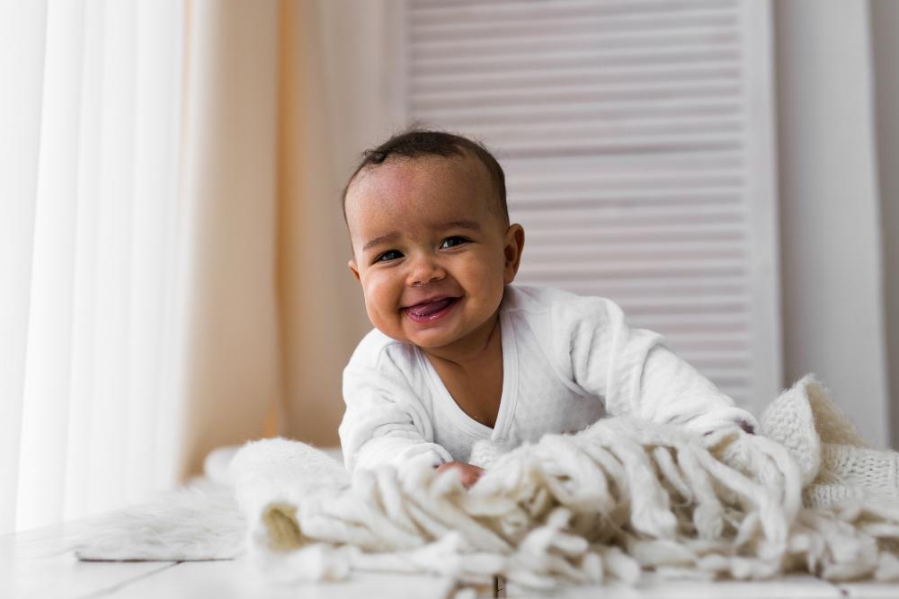 baby sitting on bed | airway dentist near me