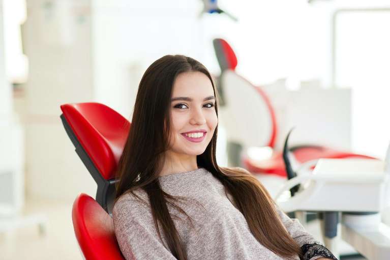 woman smiling in dentist exam chair | dentist oakbrook terrace il