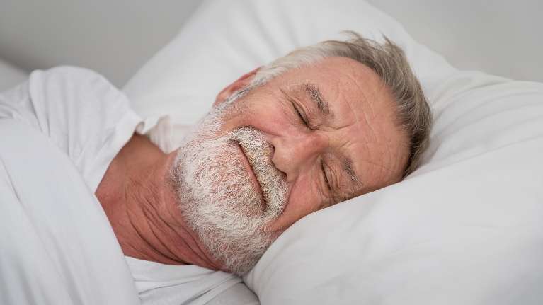 older man sleeping in bed | oakbrook terrace dentist